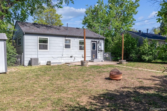 765 Iola St, Aurora, CO 80010 - back of property featuring an outdoor fire pit, central AC unit, a shingled roof, and a patio area