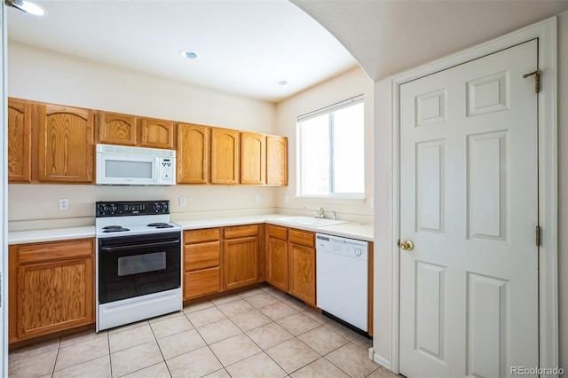 2491 Fountain Greens Blvd Unit B1, Grand Junction, CO 81505 - kitchen featuring white appliances, arched walkways, light countertops, light tile patterned floors, and brown cabinetry