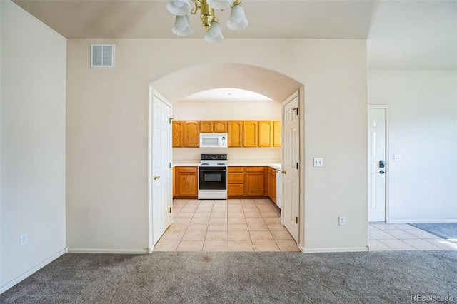 2491 Fountain Greens Blvd Unit B1, Grand Junction, CO 81505 - kitchen with white appliances, a chandelier, arched walkways, light tile patterned floors, and light colored carpet