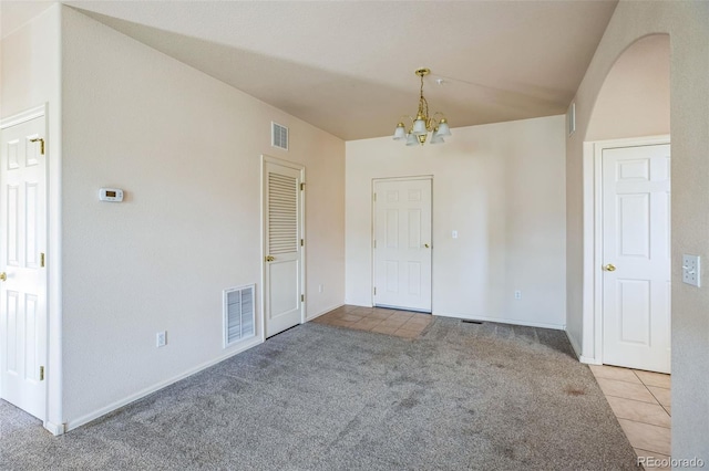 2491 Fountain Greens Blvd Unit B1, Grand Junction, CO 81505 - unfurnished dining area with tile patterned floors, a chandelier, carpet floors, and arched walkways