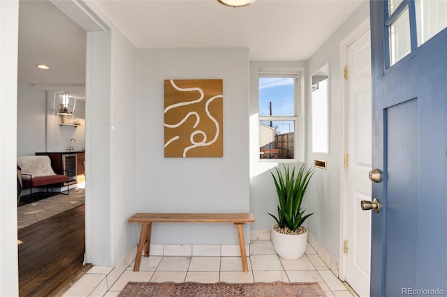 entryway with wine cooler, light tile patterned floors, and baseboards