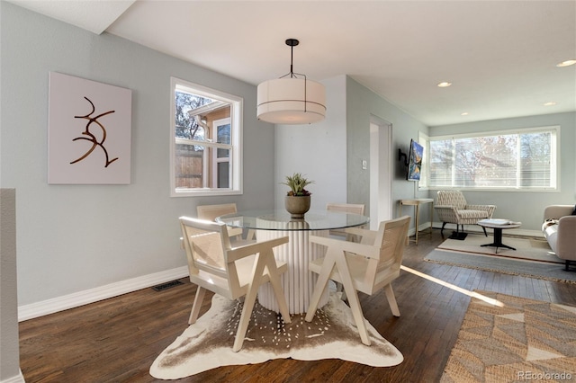 dining space with plenty of natural light and dark wood-type flooring