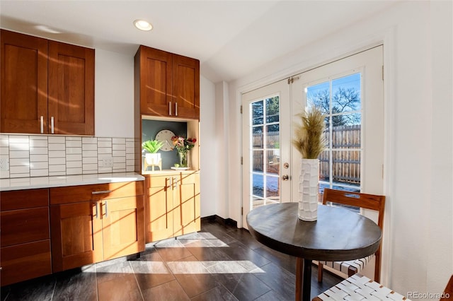 kitchen with dark hardwood / wood-style flooring, backsplash, vaulted ceiling, and french doors