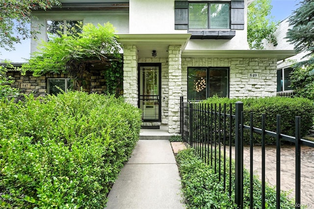 549 Milwaukee St, Denver, CO 80206 - doorway to property with stone siding, stucco siding, and a porch
