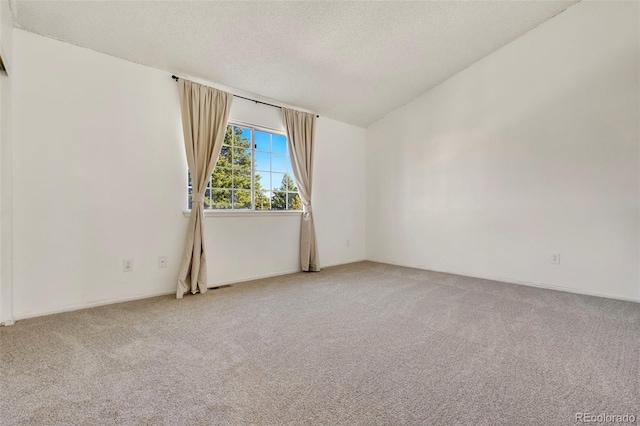 unfurnished room with light carpet, visible vents, and a textured ceiling