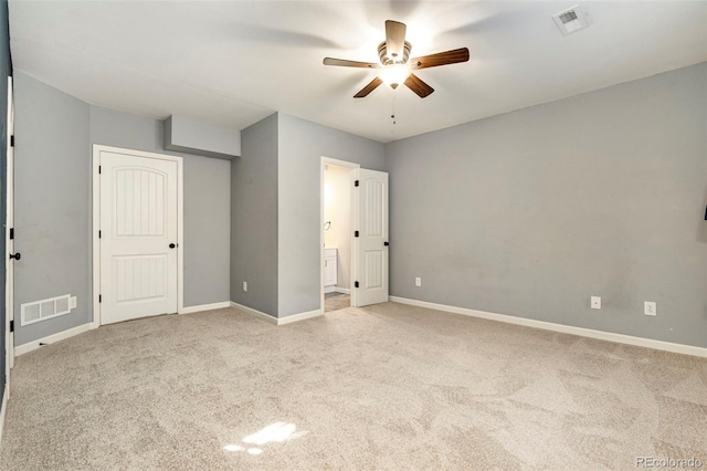 unfurnished bedroom featuring ensuite bathroom, baseboards, visible vents, and carpet floors