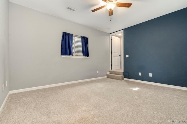 empty room featuring baseboards, visible vents, carpet floors, ceiling fan, and stairs