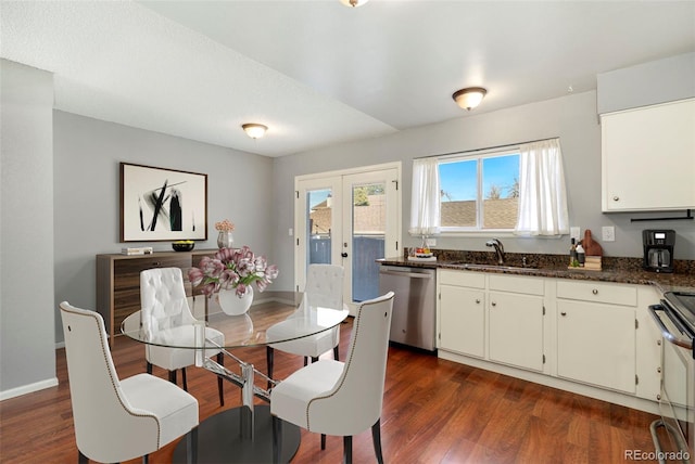 kitchen with dark wood-type flooring, a sink, stainless steel appliances, french doors, and baseboards