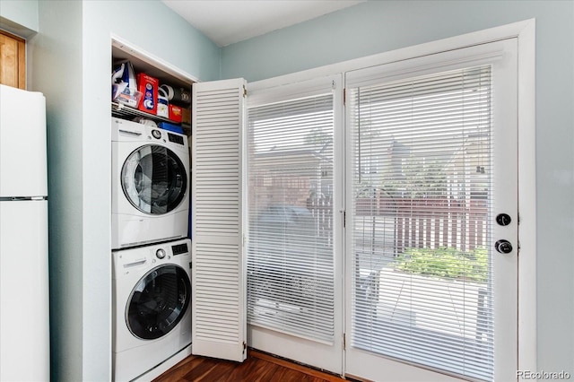 washroom featuring stacked washer / dryer and dark hardwood / wood-style flooring