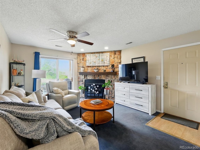 living room with a ceiling fan, a stone fireplace, a textured ceiling, carpet floors, and recessed lighting