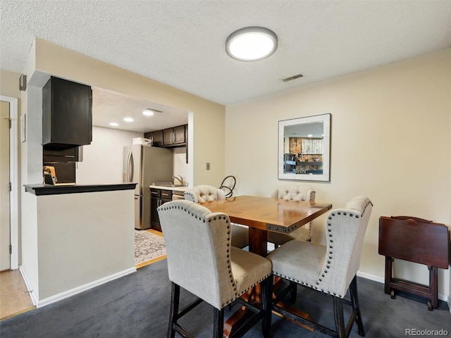 dining room with baseboards and dark colored carpet