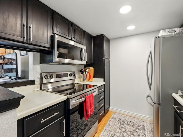 kitchen with stainless steel appliances, light wood-type flooring, recessed lighting, light countertops, and baseboards
