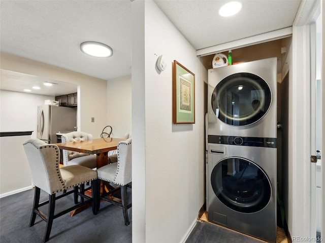 laundry room featuring estacked washer and dryer and baseboards
