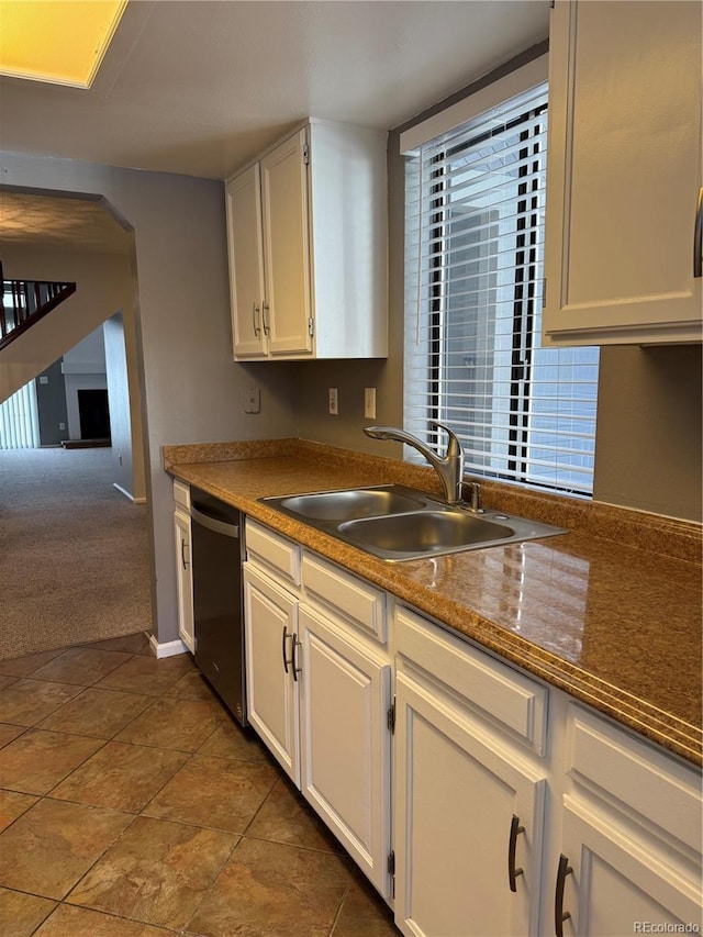 kitchen with dark carpet, dishwasher, sink, and white cabinets