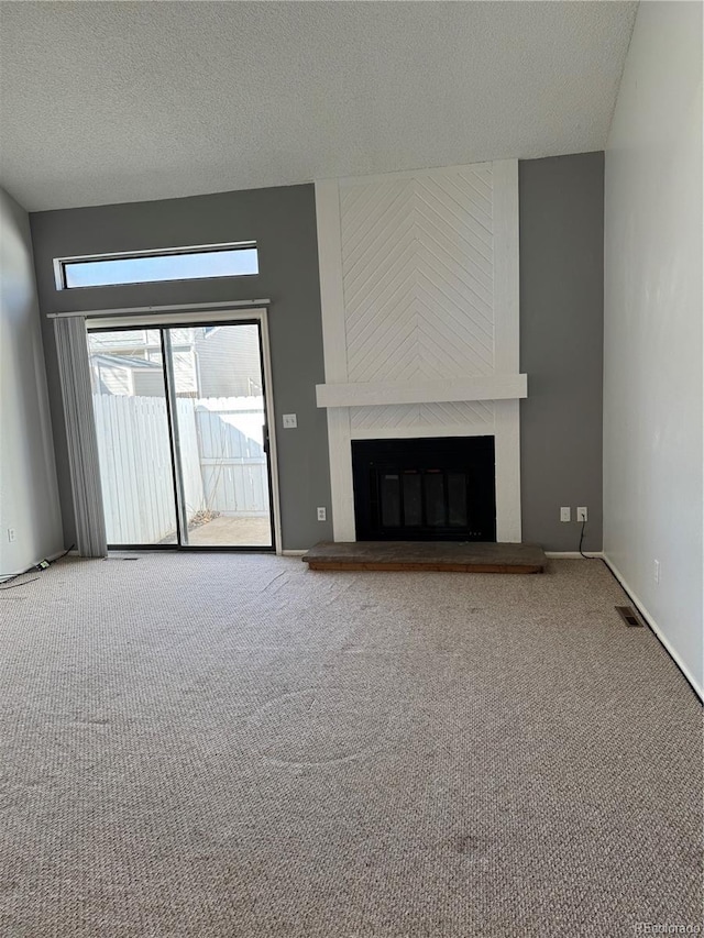 unfurnished living room with a high end fireplace, a textured ceiling, and carpet