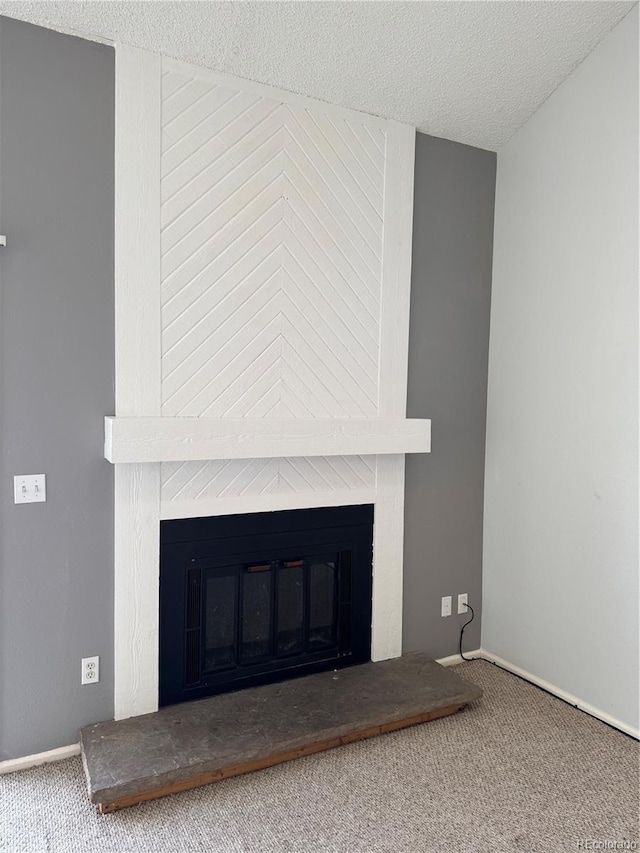 room details with carpet floors, a large fireplace, and a textured ceiling