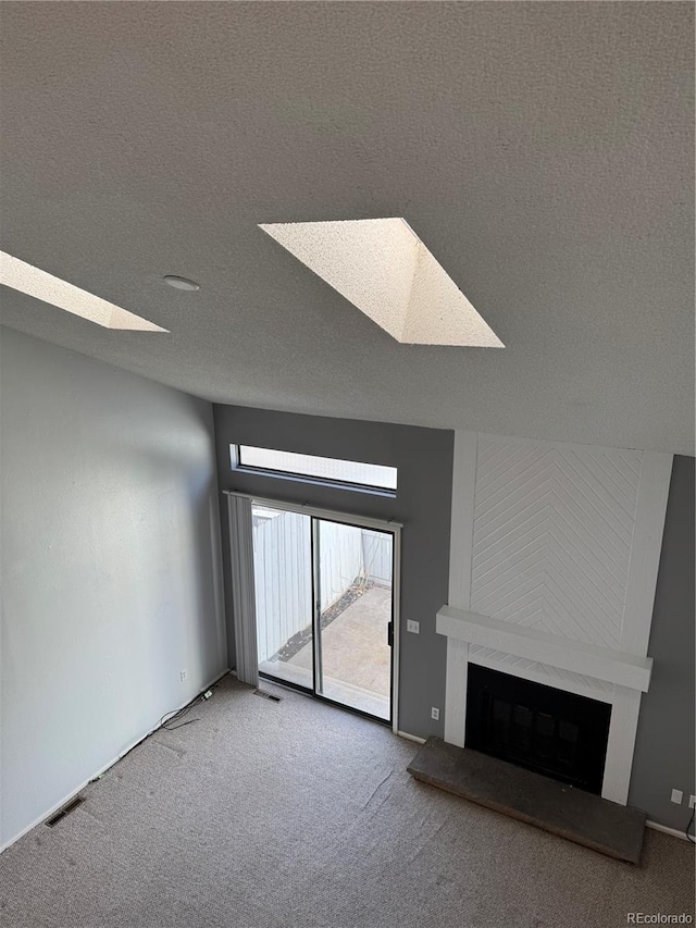 unfurnished living room featuring a premium fireplace, carpet, and a textured ceiling