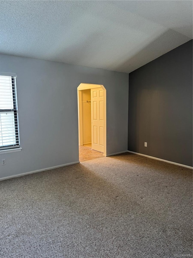 carpeted spare room with a textured ceiling