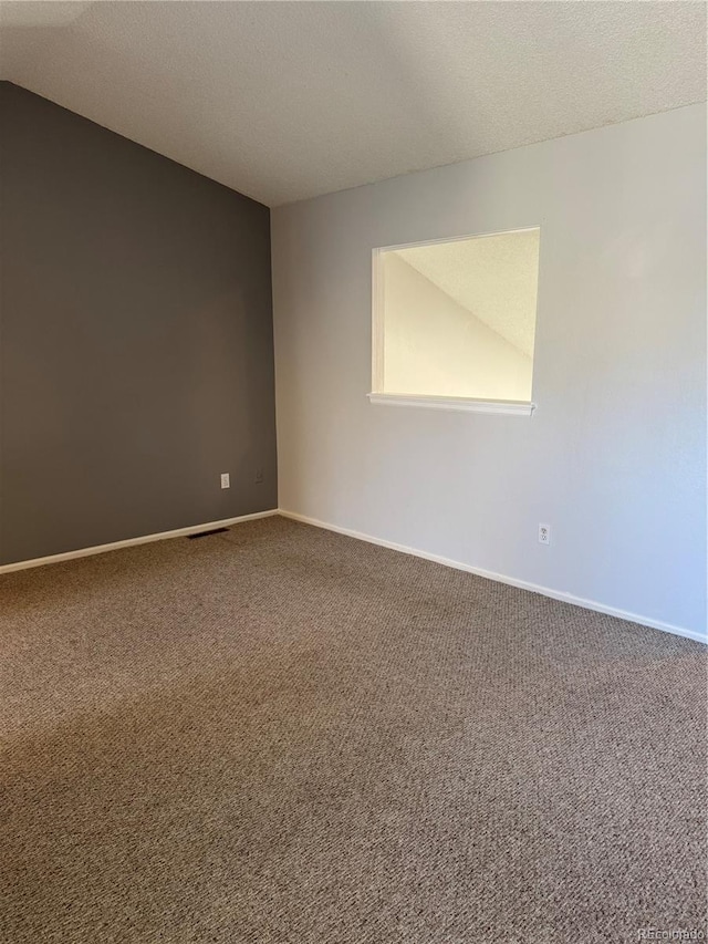 carpeted spare room with a textured ceiling