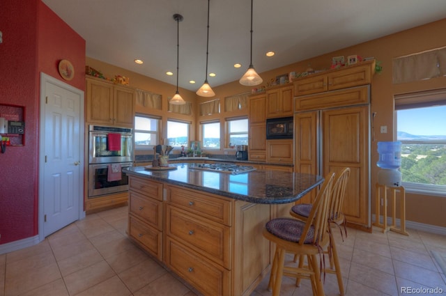 kitchen featuring light tile patterned floors, built in appliances, a kitchen island, and a healthy amount of sunlight