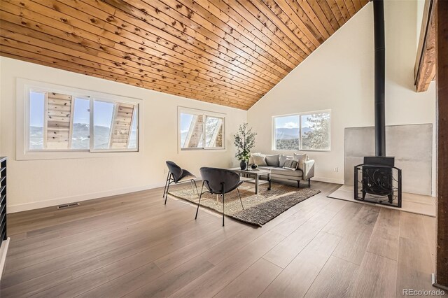 2037 Mockingbird Trl, Bailey, CO 80421 - living room featuring a wood stove, high vaulted ceiling, baseboards, wooden ceiling, and wood finished floors
