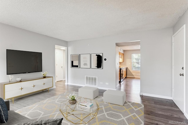 living room with wood-type flooring and a textured ceiling