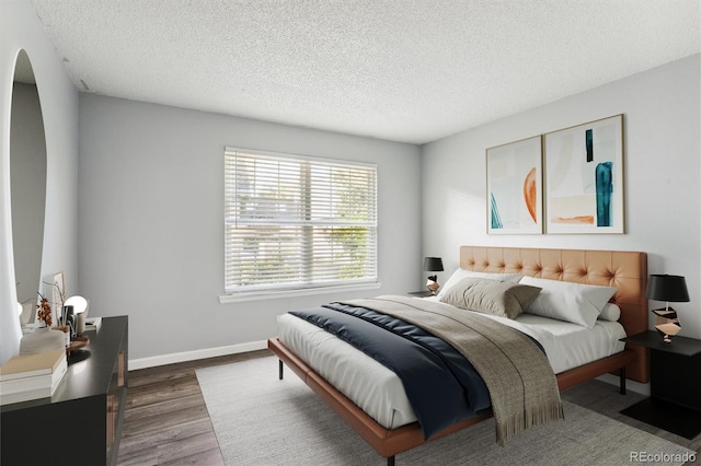 bedroom with wood-type flooring and a textured ceiling