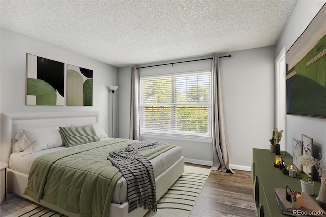 bedroom with hardwood / wood-style flooring and a textured ceiling