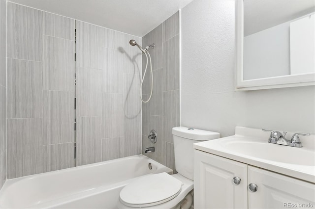 full bathroom featuring a textured ceiling, tiled shower / bath, vanity, and toilet