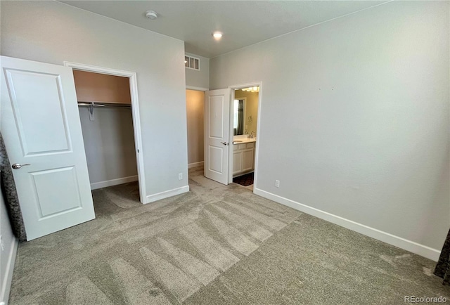 unfurnished bedroom featuring baseboards, visible vents, a walk in closet, carpet flooring, and a closet