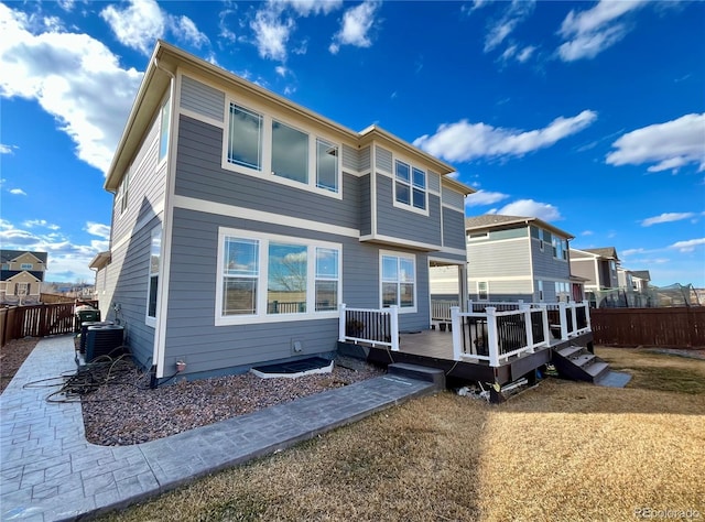 rear view of house featuring a deck, central AC, and a fenced backyard