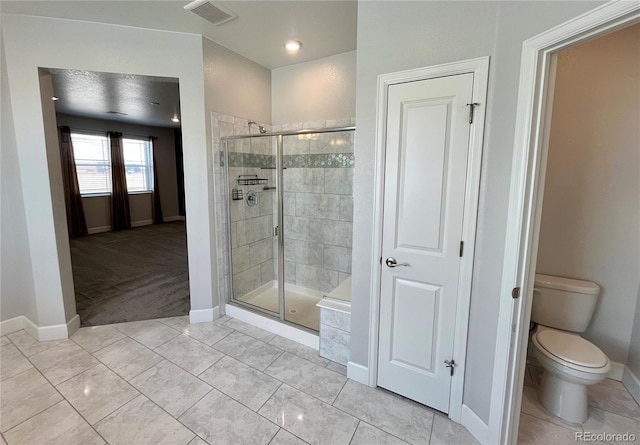 bathroom featuring toilet, a stall shower, visible vents, and tile patterned floors