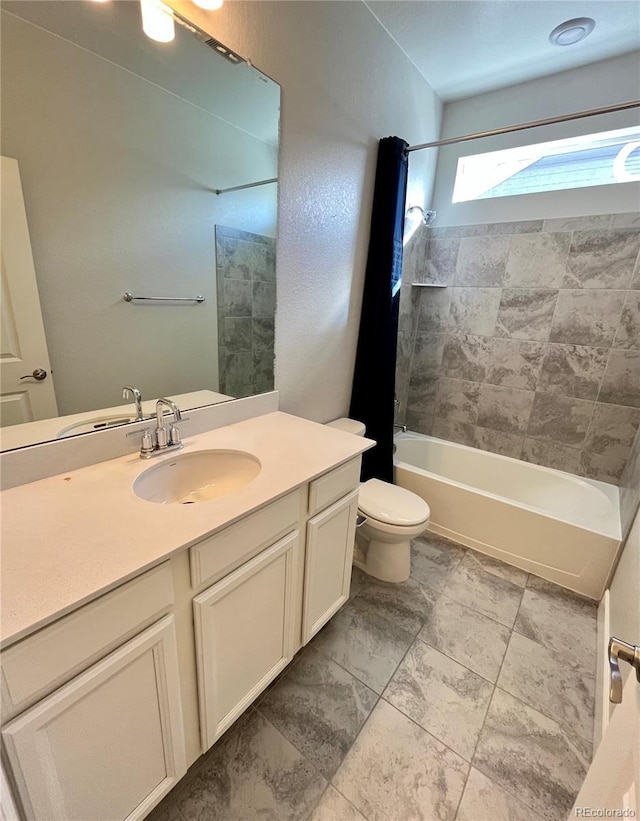 bathroom featuring toilet, vanity, and shower / bathtub combination