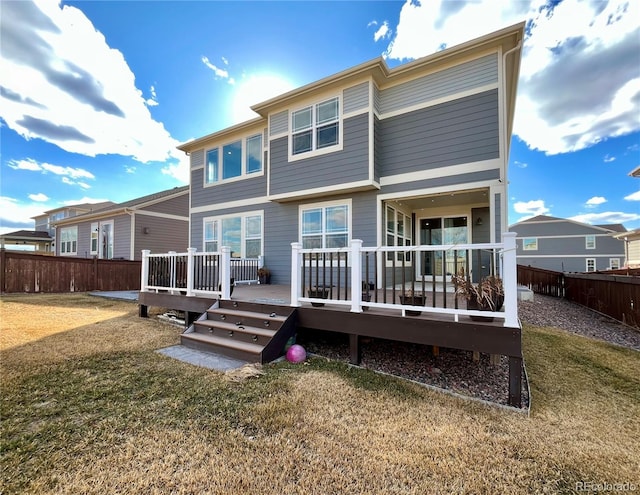 rear view of house featuring a yard, a fenced backyard, and a wooden deck