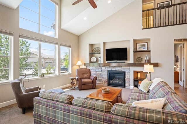 350 Andromeda Ln, Castle Rock, CO 80108 - carpeted living area with high vaulted ceiling, ceiling fan, a stone fireplace, and recessed lighting