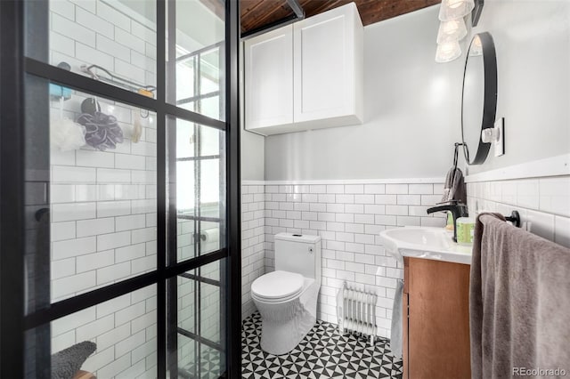 8537 S Doubleheader Hwy, Morrison, CO 80465 - full bathroom featuring radiator heating unit, toilet, a wainscoted wall, vanity, and tile walls