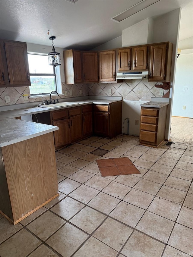 554 E Pleasant Ave, Byers, CO 80103 - kitchen with a sink, lofted ceiling, backsplash, light countertops, and under cabinet range hood