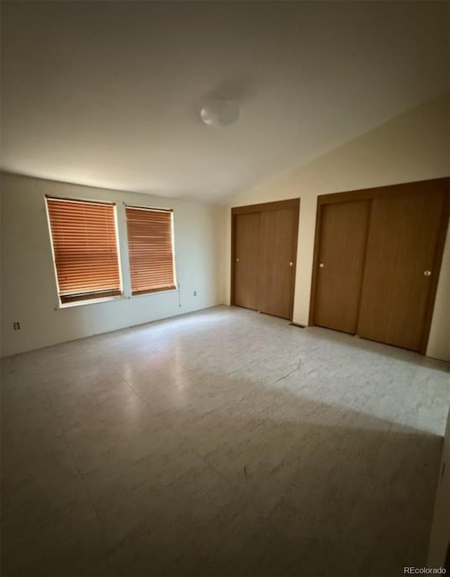 554 E Pleasant Ave, Byers, CO 80103 - unfurnished bedroom with vaulted ceiling, two closets, and light floors
