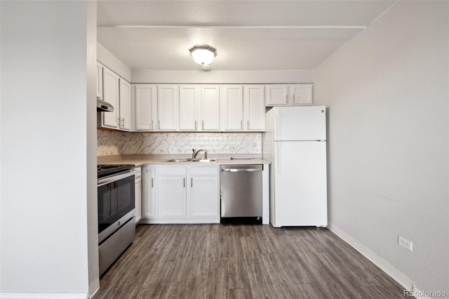 kitchen with hardwood / wood-style flooring, stainless steel appliances, decorative backsplash, white cabinetry, and sink