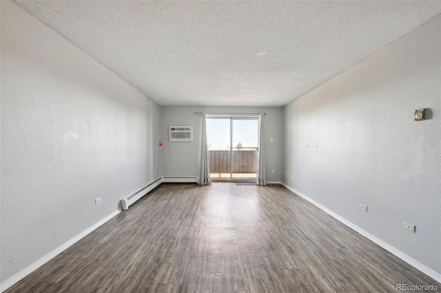 unfurnished room featuring a wall unit AC, a textured ceiling, baseboard heating, and dark hardwood / wood-style floors