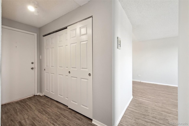 hall featuring a textured ceiling and hardwood / wood-style floors