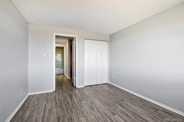 unfurnished bedroom with dark wood-type flooring, a textured ceiling, and a closet