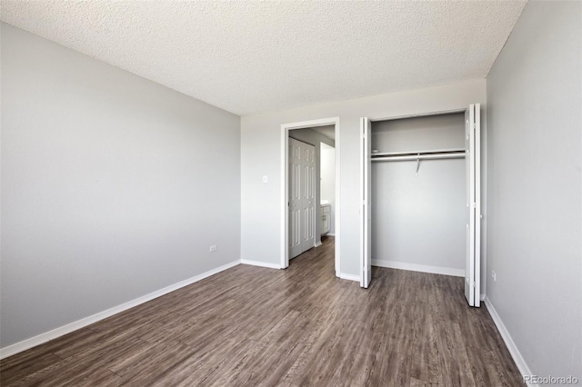 unfurnished bedroom with a textured ceiling, a closet, and dark hardwood / wood-style flooring