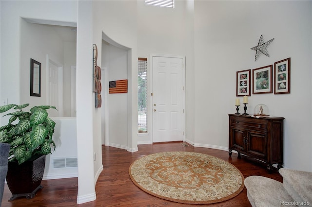 entrance foyer with dark wood-type flooring and a high ceiling