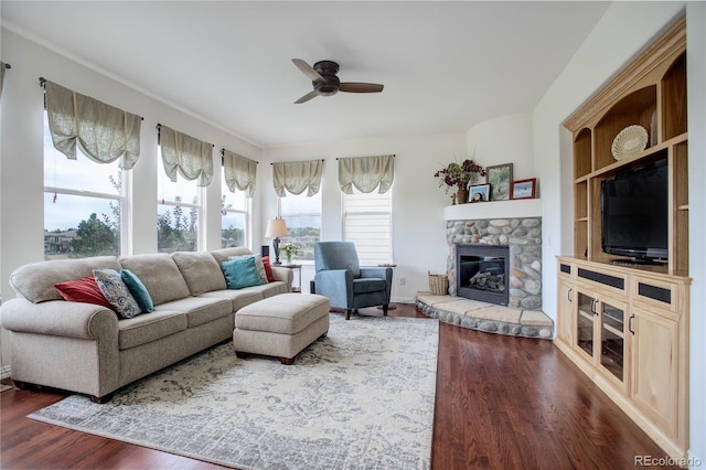 living room featuring a fireplace, dark hardwood / wood-style flooring, built in features, and ceiling fan