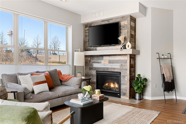 living room featuring hardwood / wood-style flooring and a stone fireplace