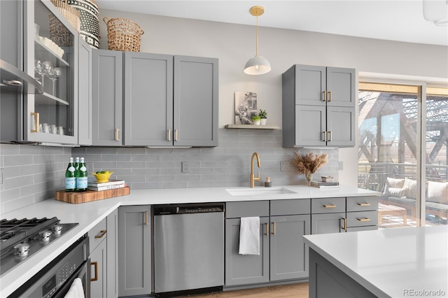 kitchen featuring stainless steel dishwasher, gray cabinets, and decorative backsplash