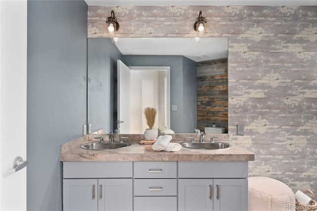 bathroom with vanity, brick wall, and toilet