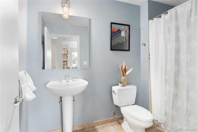 bathroom featuring tile patterned flooring, curtained shower, and toilet