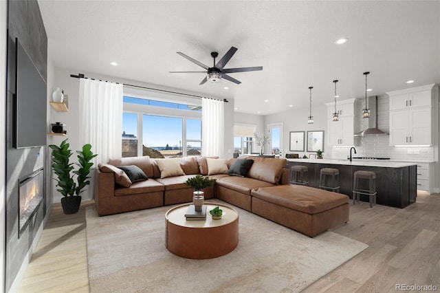 living room featuring ceiling fan and light wood-type flooring